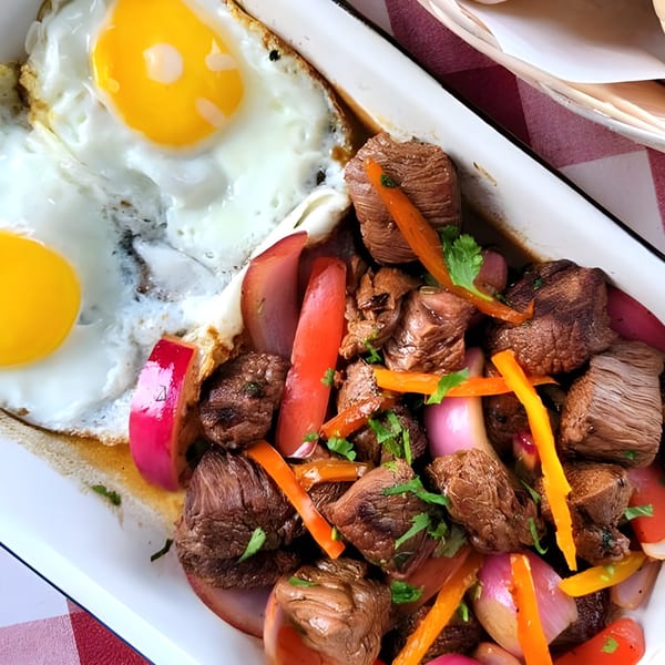 La Piccolina's beef stir-fry with peppers and onions, served with two fried eggs.