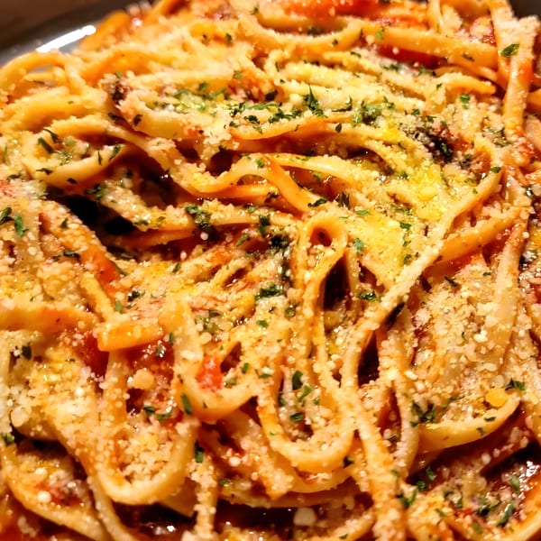 Close-up of La Piccolina's linguine pasta with red sauce, parmesan cheese, and fresh parsley.